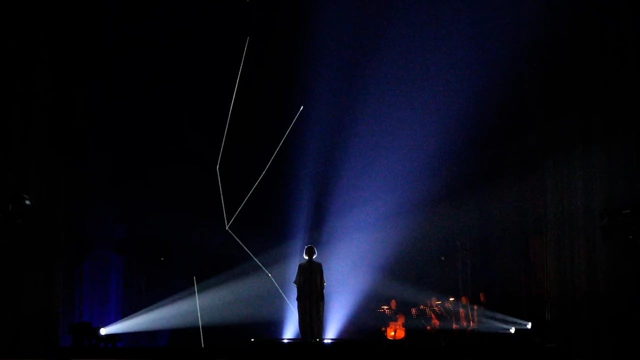 Silhouette auf der Bühne unter einem blauen Lichtstrahl – ELECTRIC CHURCH, Votivkirche, Wien, Österreich