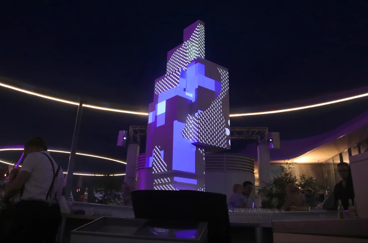 Geometrische 3D-Skulptur mit violetten und weißen Mapping-Mustern – MQ LIBELLE, MQ Libelle, Wien, Österreich