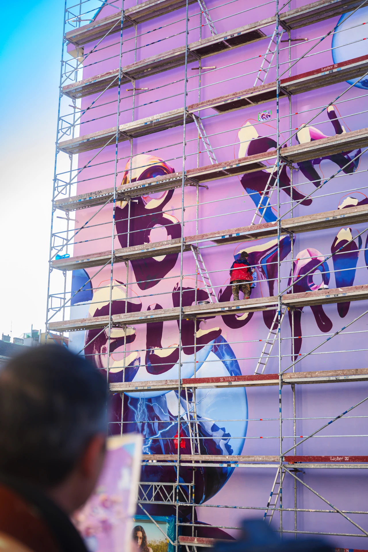 Working on the BornElectric mural from facade scaffolding – BMW - BORNELECTRIC, Linke Wienzeile, Vienna, Austria