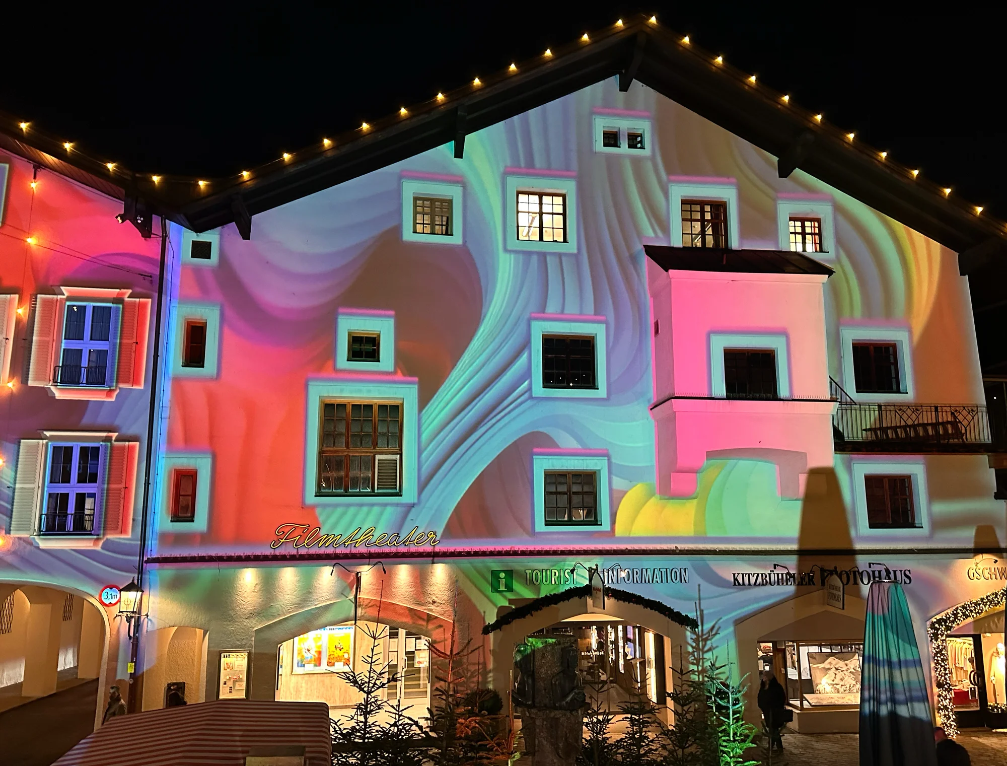 Nahansicht einer rosa und grün projizierten Fassade über einem Torbogen