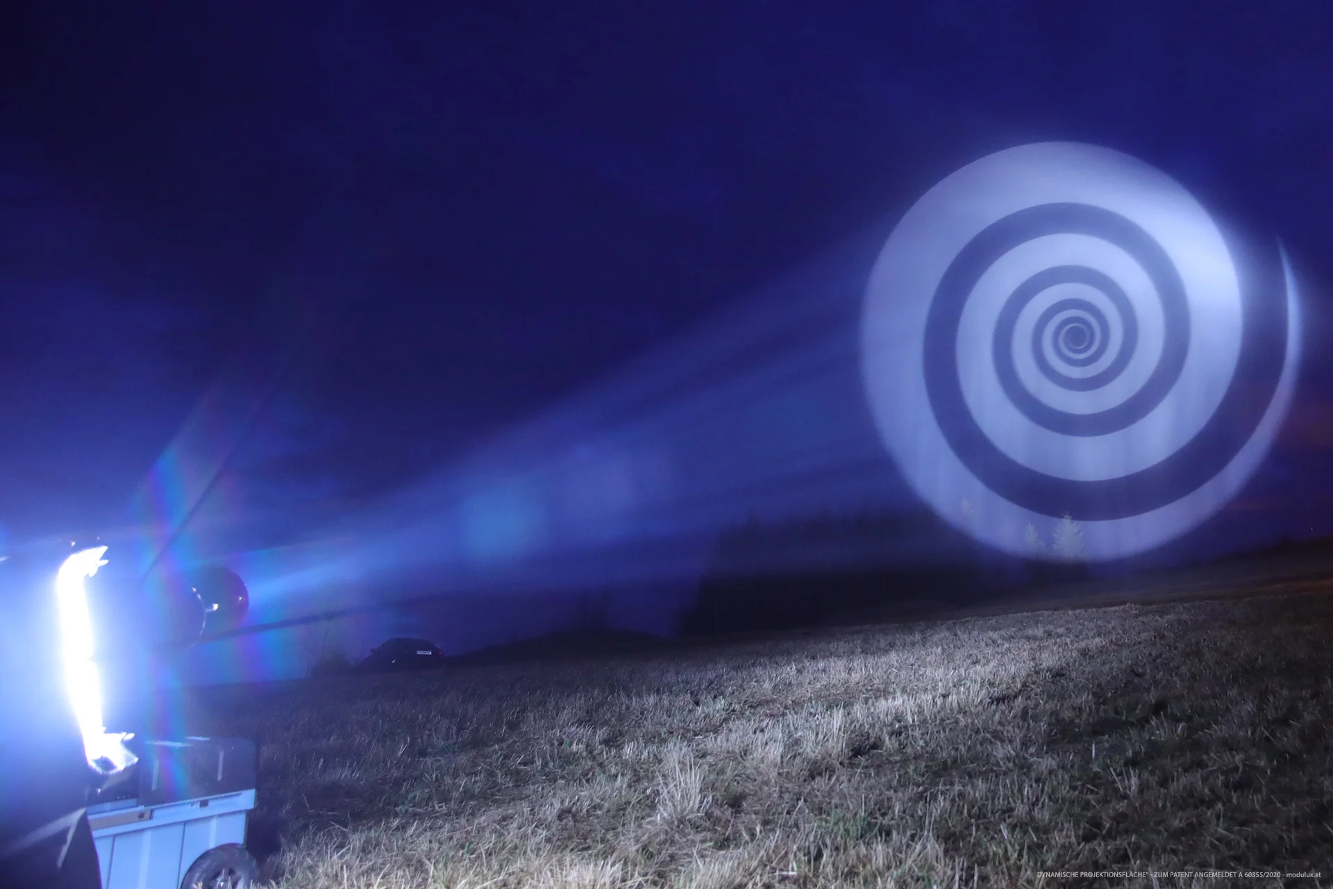Spiralmotiv auf Wasserpartikeln mit seitlich sichtbarem Projektionsstrahl