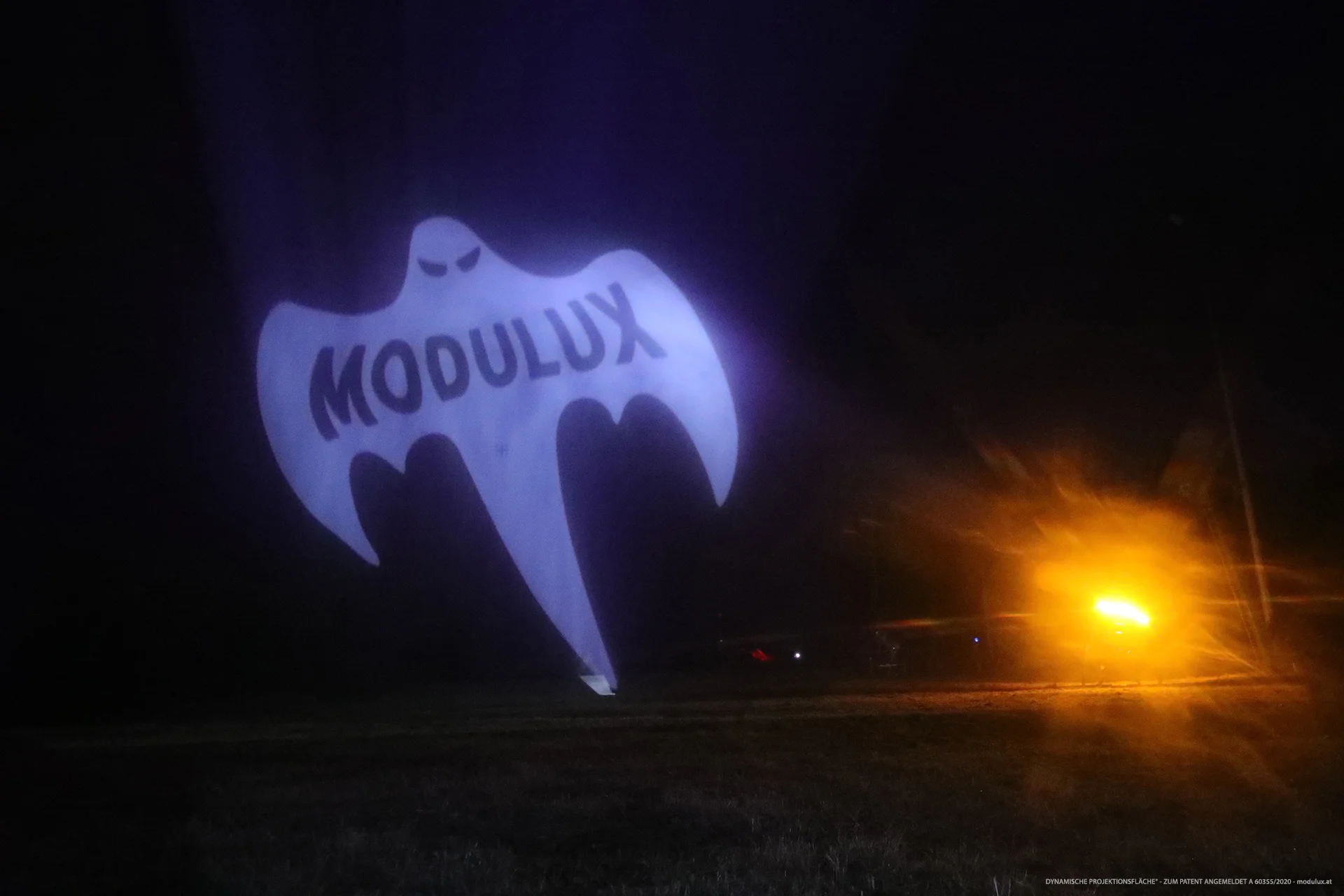 MODULUX-Ghost als weiße Projektion auf Wasserpartikel bei Nacht