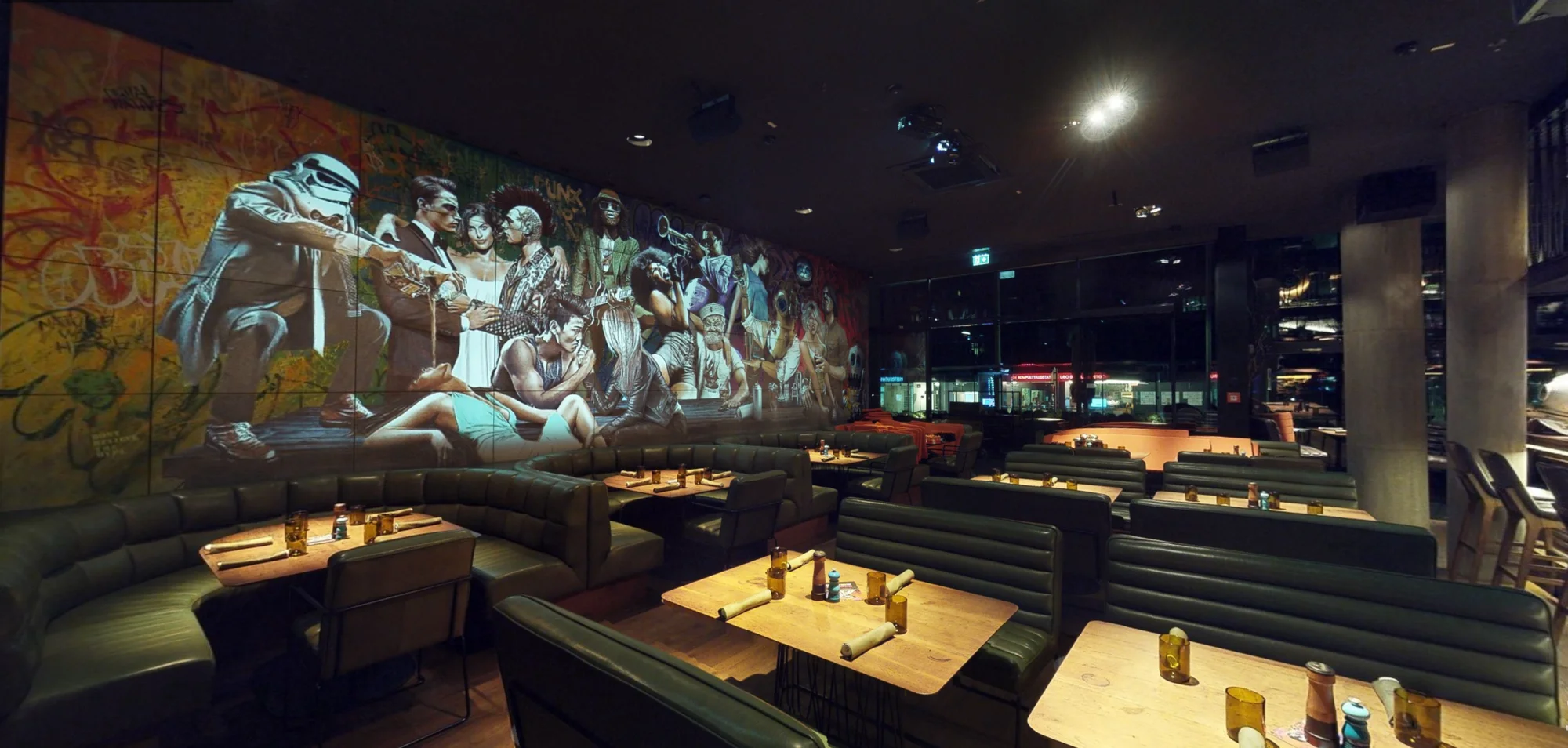 Seitliche Ansicht des projizierten Murals über den Restauranttischen