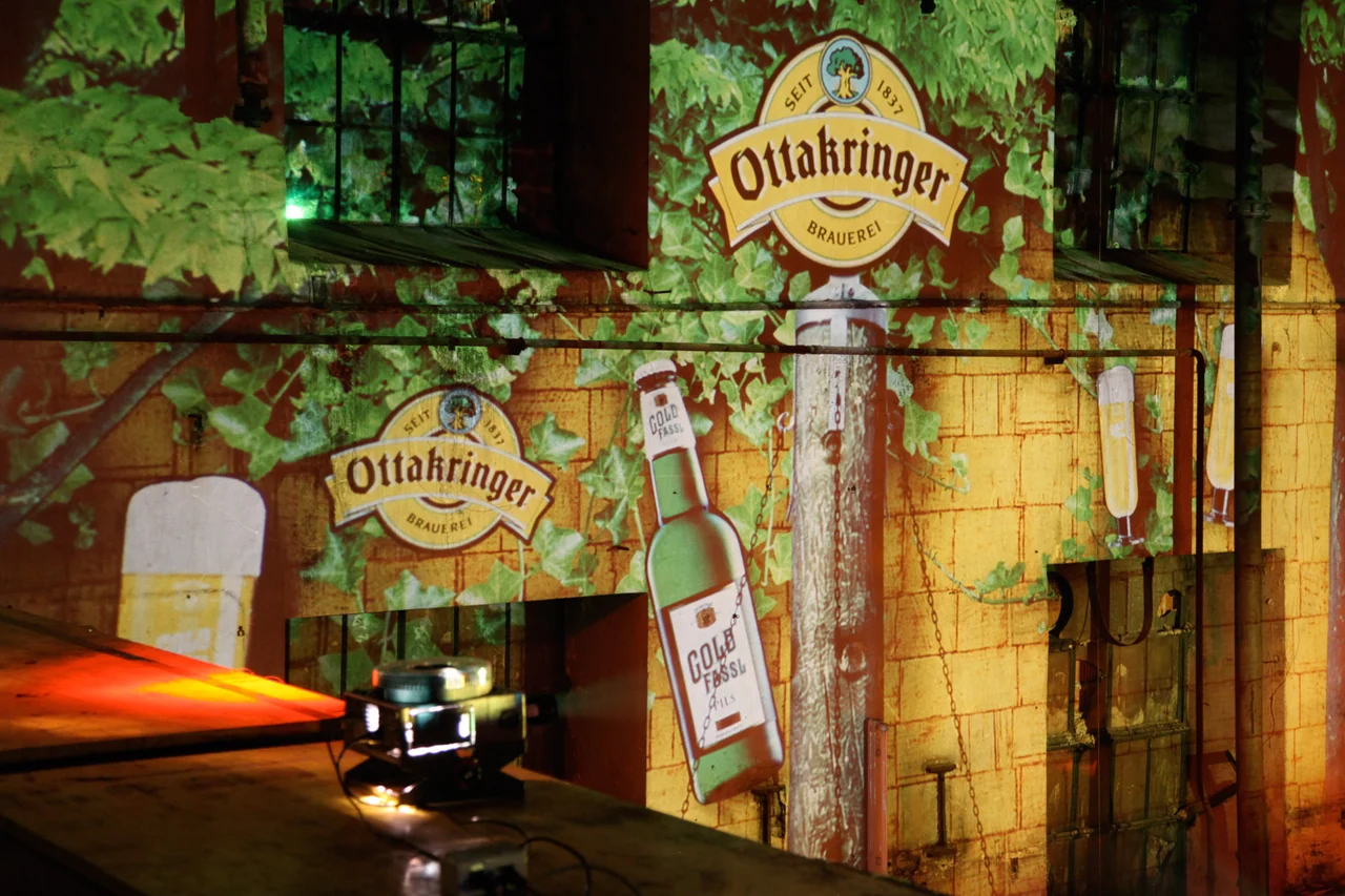 Nahansicht von Markenprojektionen auf Wand und Fenstern der Brauerei – Ottakringer Maifest, Ottakringer Brauerei, Wien, Österreich
