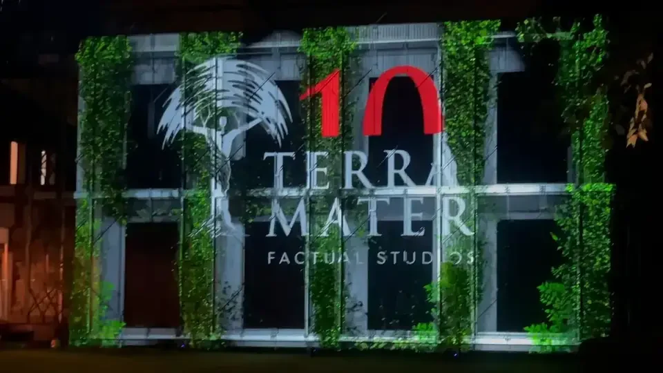 Terra-Mater-Jubiläumsmotiv zwischen projizierten Pflanzen auf der Fassade – TERRA MATER, Wien, Österreich