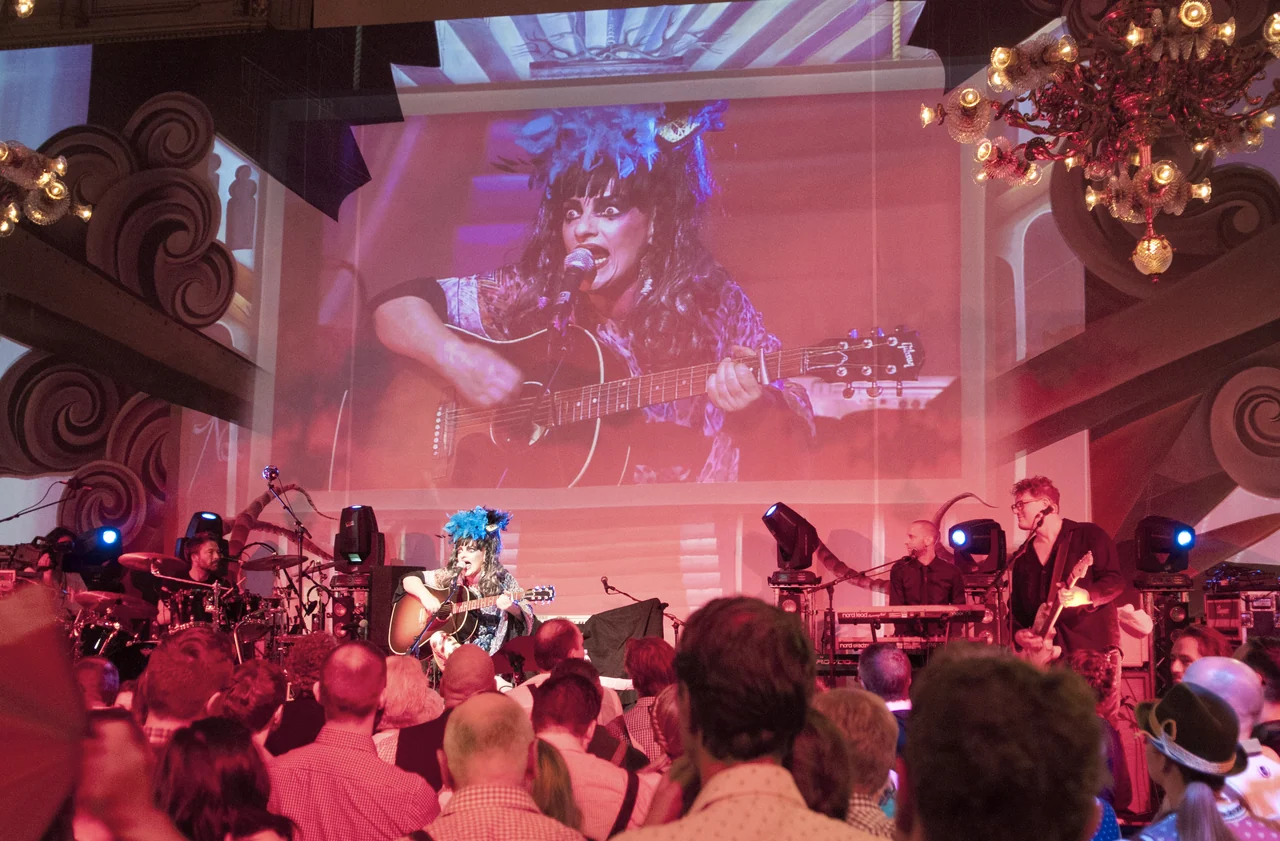Large live image of a musician behind the concert stage – ALMDUDLER TRACHTEN-PÄRCHENBALL, City Hall, Vienna, Austria
