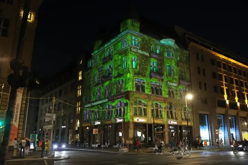 Grüne Fassadenprojektion auf ein mehrgeschossiges Gebäude – FESTIVAL OF LIGHTS, Berlin, Deutschland