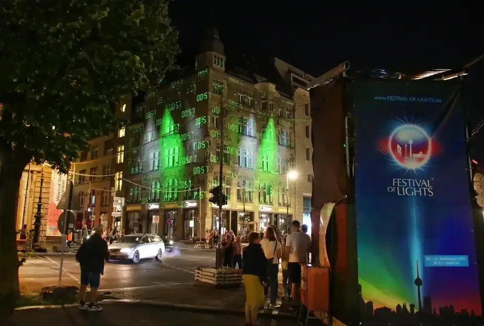 Grüne Fassadenprojektion auf ein mehrgeschossiges Gebäude – FESTIVAL OF LIGHTS, Berlin, Deutschland