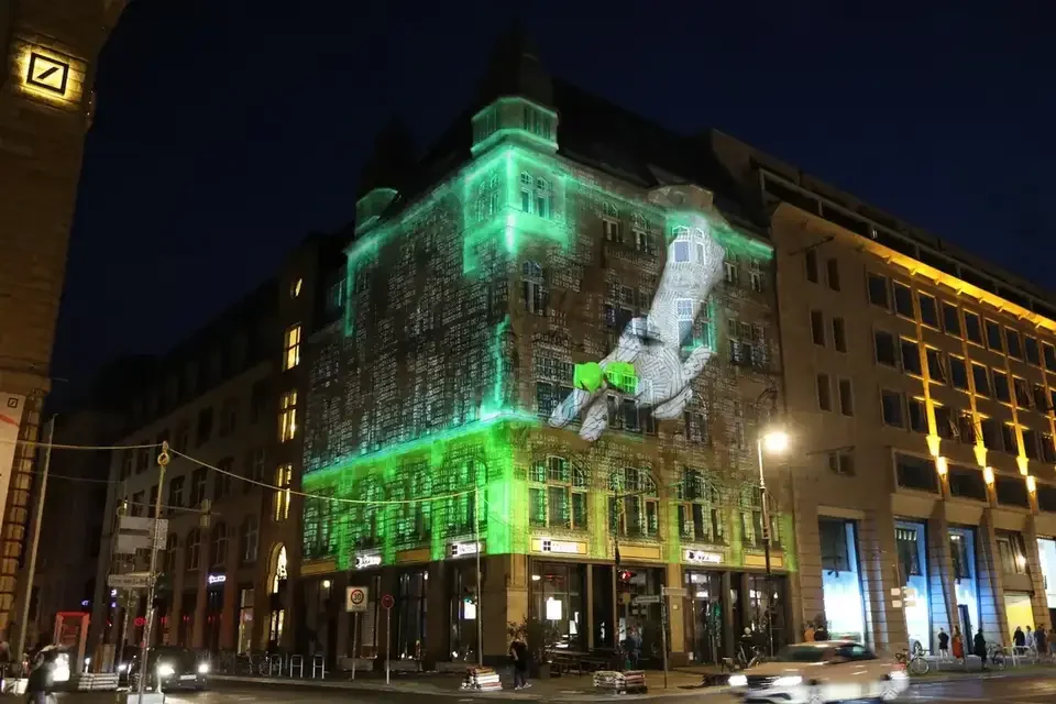 Grüne Fassadenprojektion auf ein mehrgeschossiges Gebäude – FESTIVAL OF LIGHTS, Berlin, Deutschland