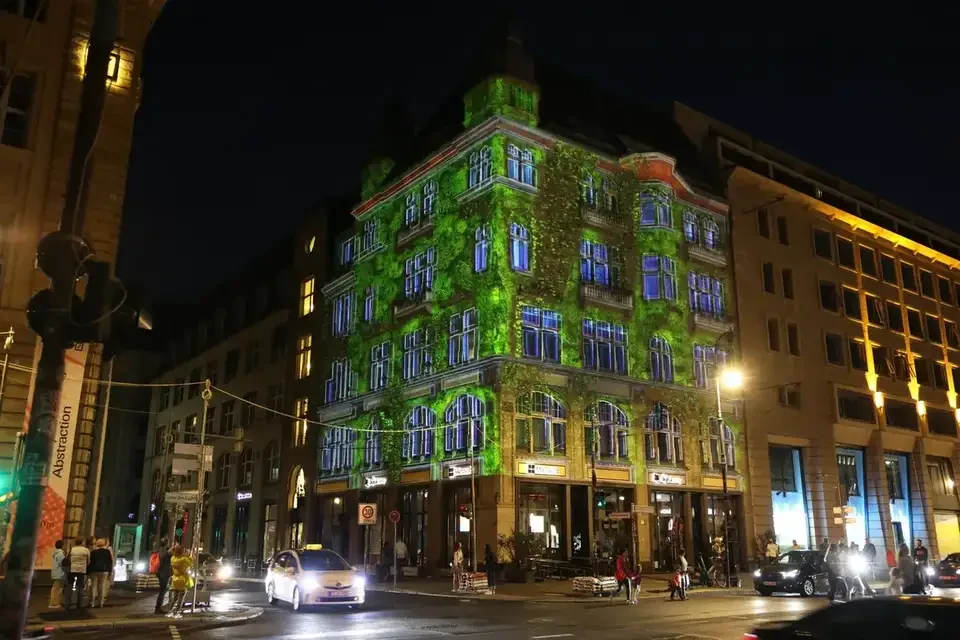 Grüne Fassadenprojektion auf ein mehrgeschossiges Gebäude – FESTIVAL OF LIGHTS, Berlin, Deutschland