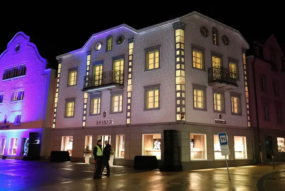 Beleuchtete Gebäudefassade mit sichtbaren Fenstern und Balkonen – HUBER OPENING, Huber Fine Watches & Jewellery, Bregenz, Österreich