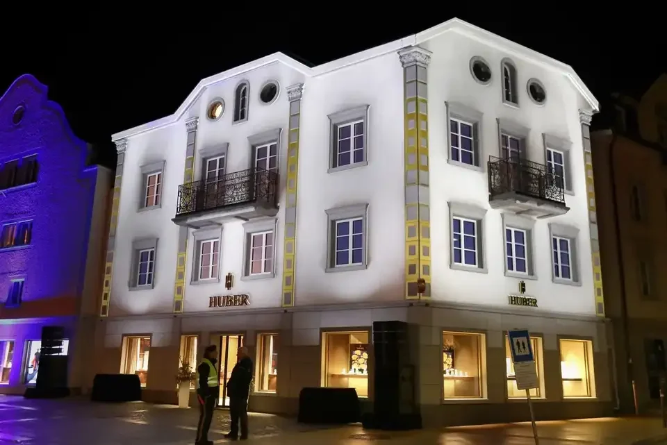 Weiße Fassadenprojektion mit architektonischen Konturen – HUBER OPENING, Huber Fine Watches & Jewellery, Bregenz, Österreich