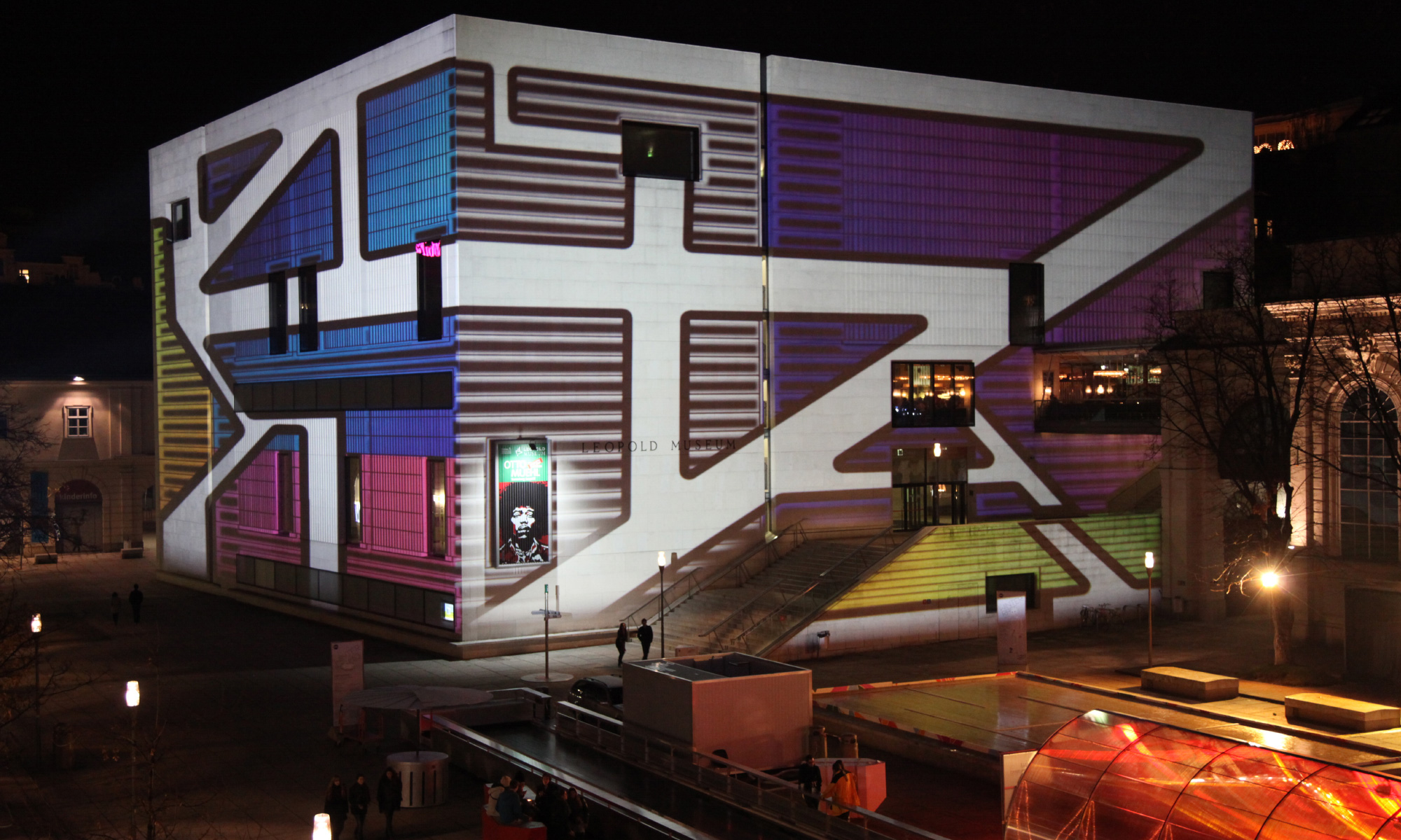 Bunte Projektionsmotive um Fenster und Fassadengliederung – WINTER IM MQ, MuseumsQuartier, Wien, Österreich