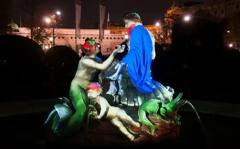 Grüne und blaue Projektionen auf die Figuren eines Brunnens – WIEN LEUCHTET, Kunsthistorisches und Naturhistorisches Museum, Wien, Österreich