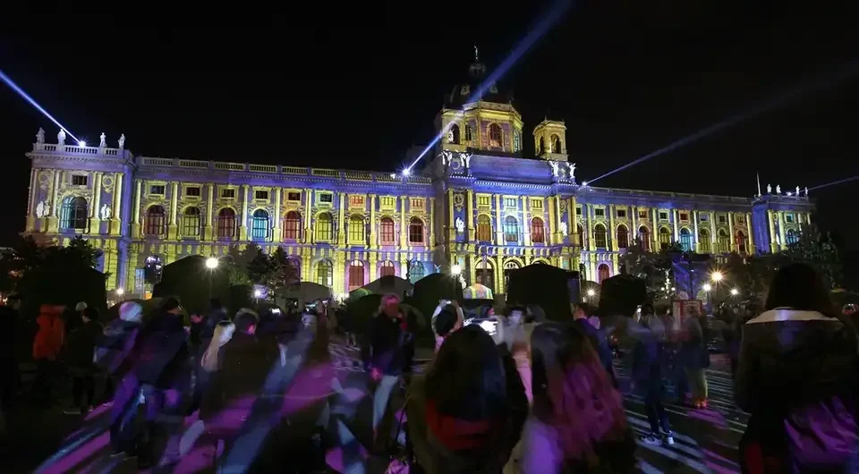 Publikum vor einer projizierten Museumsfassade mit Lichtstrahlen – WIEN LEUCHTET, Kunsthistorisches und Naturhistorisches Museum, Wien, Österreich