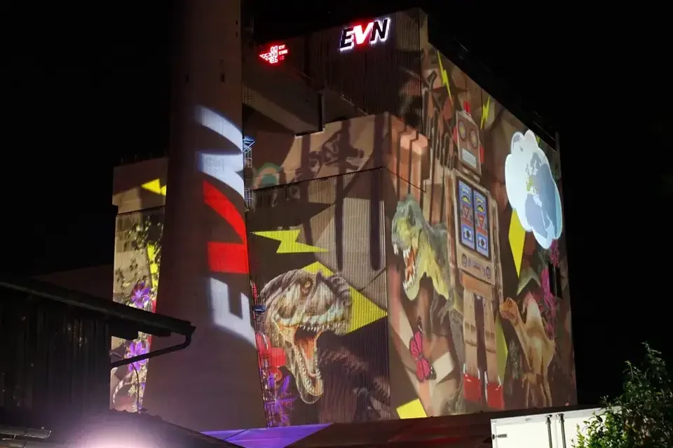 Bunte Bildcollage als Großbildprojektion auf ein Kraftwerksgebäude – TOMORROW FESTIVAL, Kernkraftwerk, Zwentendorf, Österreich