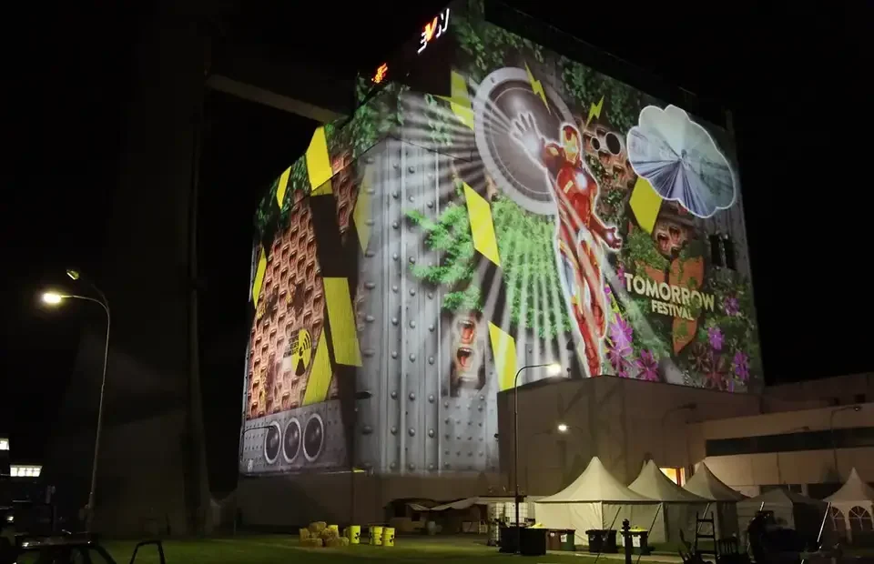 Bunte Bildcollage als Großbildprojektion auf ein Kraftwerksgebäude – TOMORROW FESTIVAL, Kernkraftwerk, Zwentendorf, Österreich
