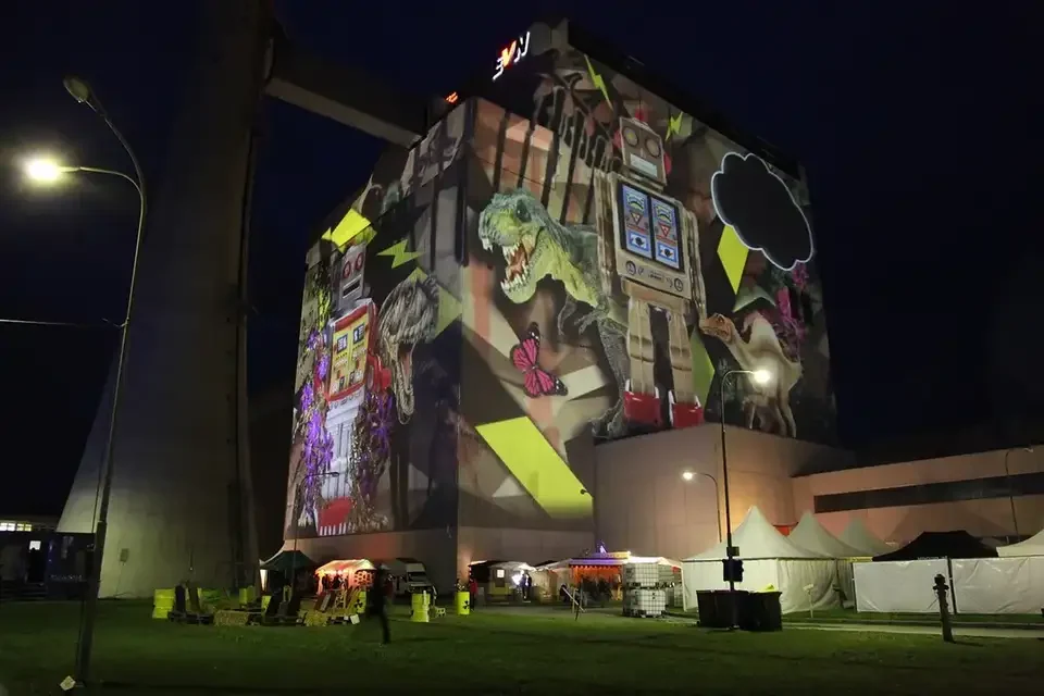 Bunte Bildcollage als Großbildprojektion auf ein Kraftwerksgebäude – TOMORROW FESTIVAL, Kernkraftwerk, Zwentendorf, Österreich