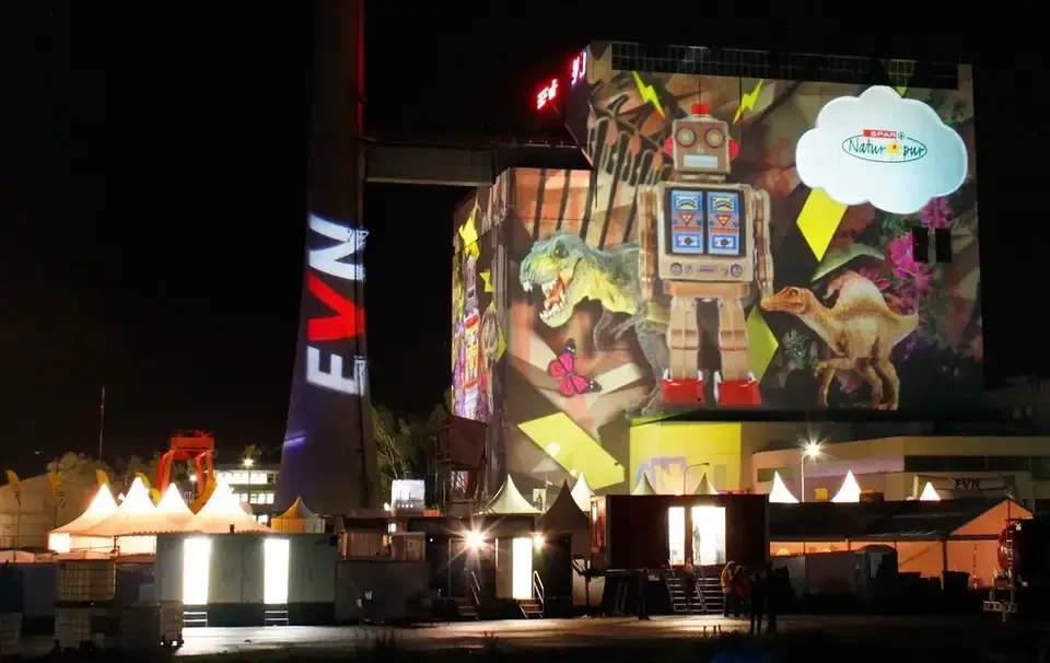 Bunte Bildcollage als Großbildprojektion auf ein Kraftwerksgebäude – TOMORROW FESTIVAL, Kernkraftwerk, Zwentendorf, Österreich