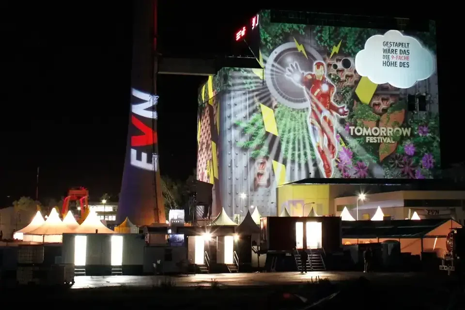 Bunte Bildcollage als Großbildprojektion auf ein Kraftwerksgebäude – TOMORROW FESTIVAL, Kernkraftwerk, Zwentendorf, Österreich