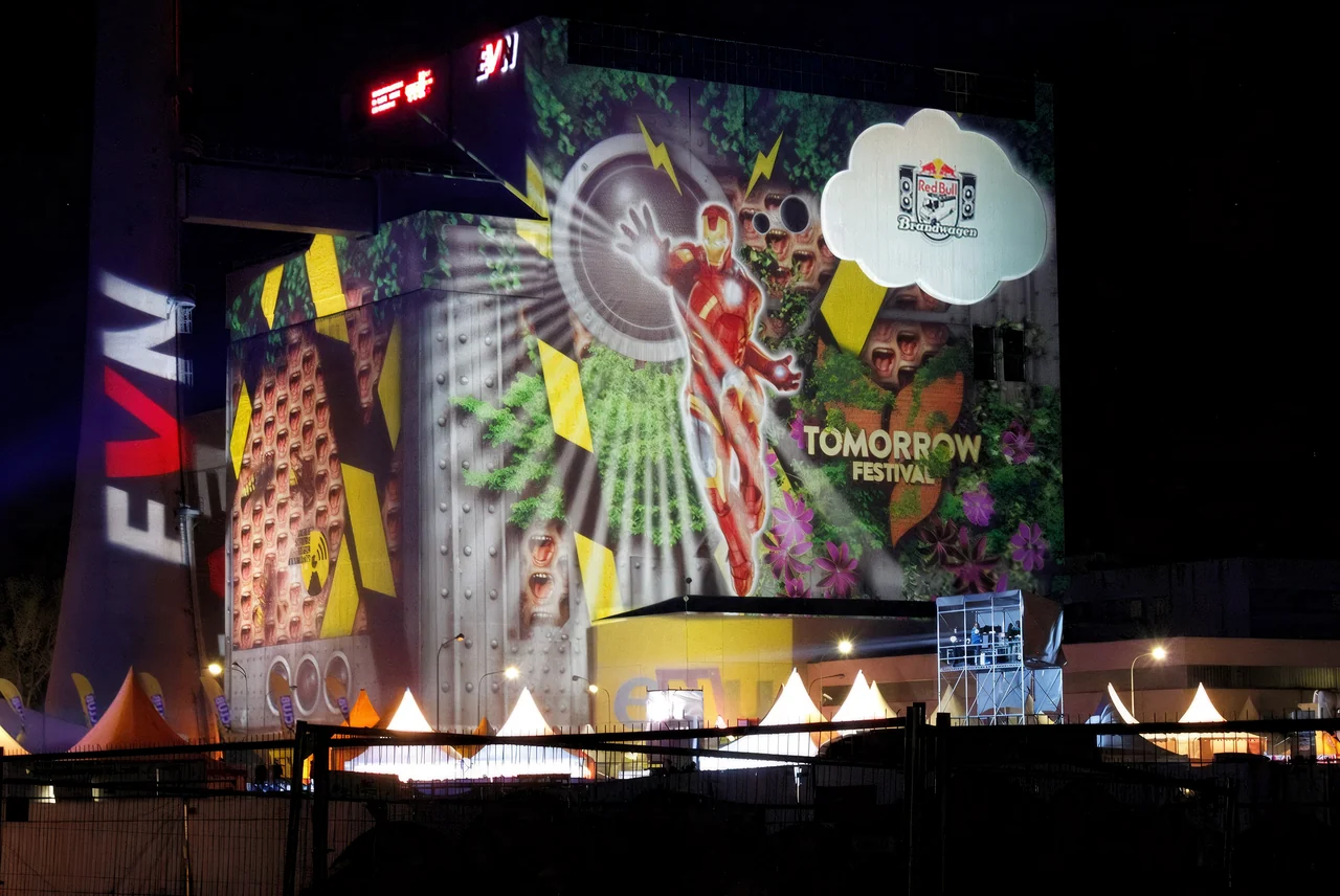 Bunte Bildcollage als Großbildprojektion auf ein Kraftwerksgebäude – TOMORROW FESTIVAL, Kernkraftwerk, Zwentendorf, Österreich