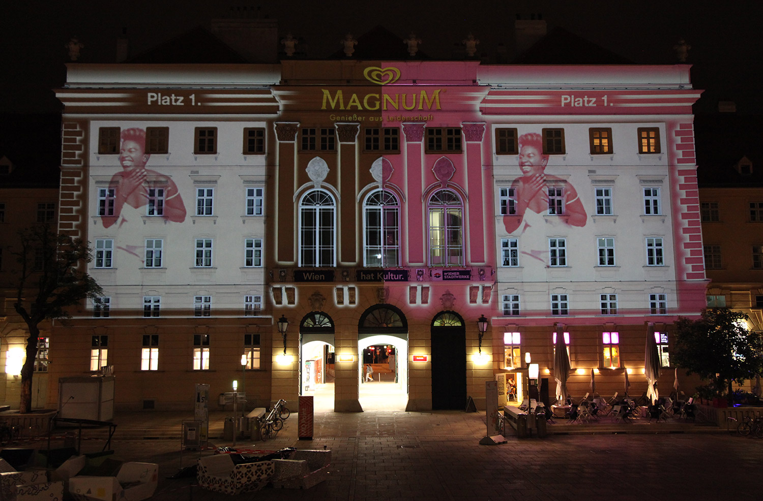 Portrait and brand imagery in pink and black projected onto a facade – MAGNUM PINK BLACK, MuseumsQuartier, Vienna, Austria