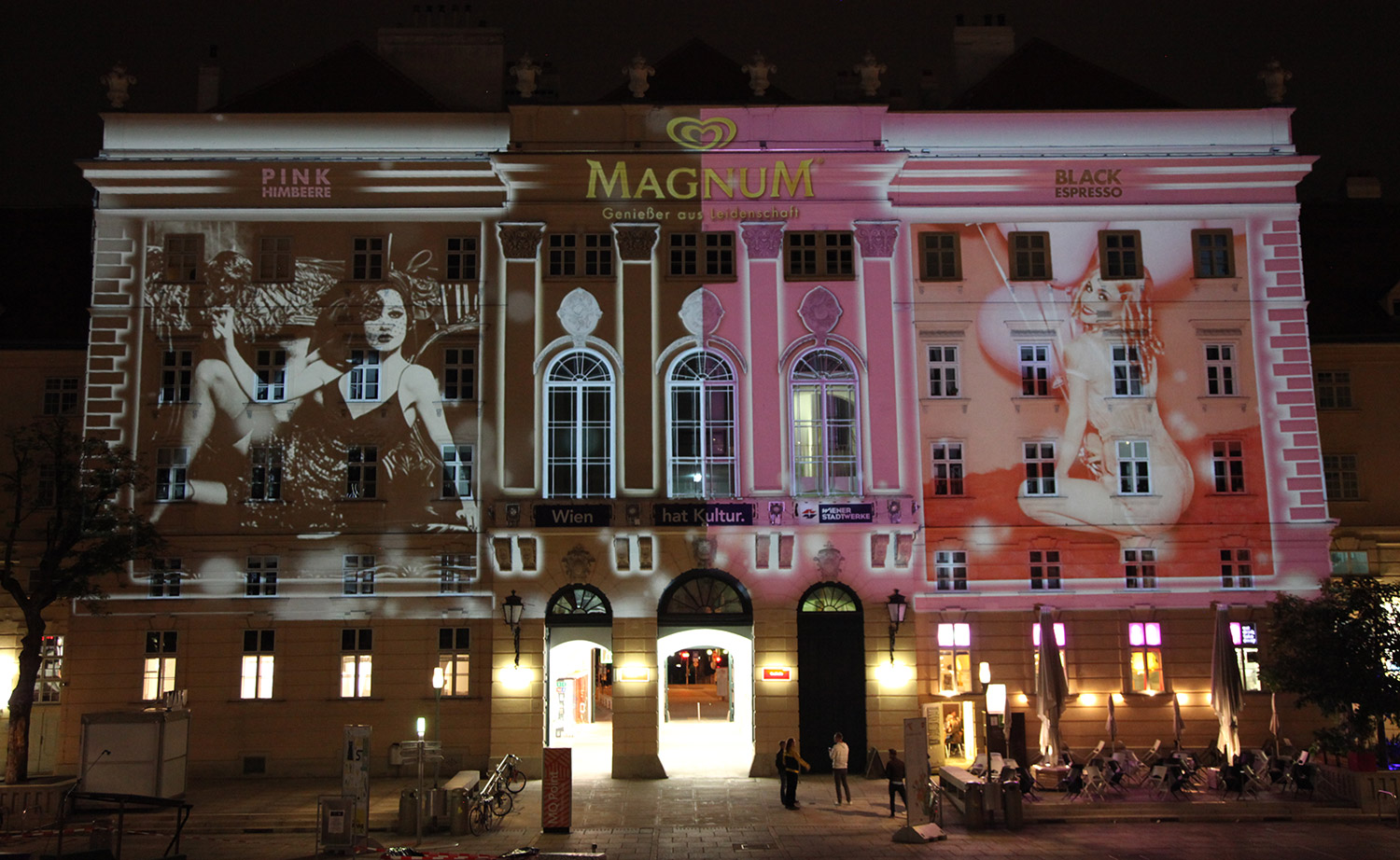 Portrait and brand imagery in pink and black projected onto a facade – MAGNUM PINK BLACK, MuseumsQuartier, Vienna, Austria