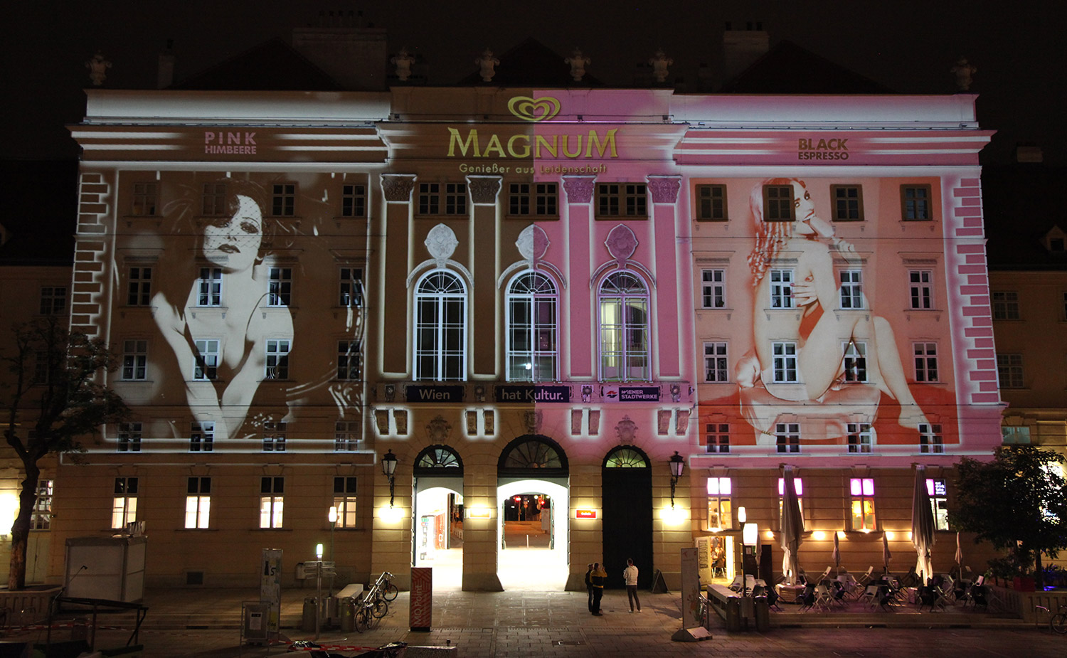 Portrait and brand imagery in pink and black projected onto a facade – MAGNUM PINK BLACK, MuseumsQuartier, Vienna, Austria