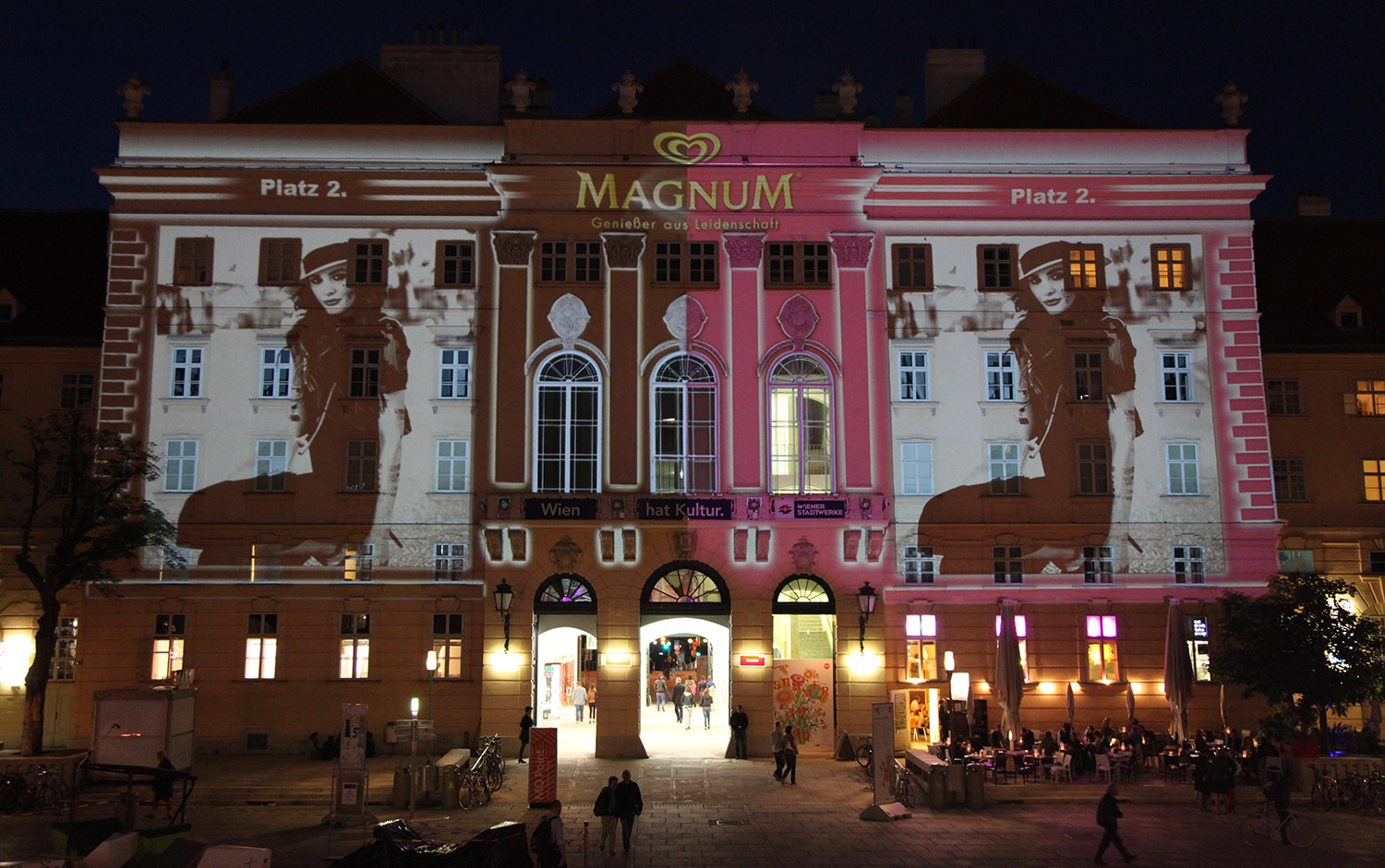 Portrait and brand imagery in pink and black projected onto a facade – MAGNUM PINK BLACK, MuseumsQuartier, Vienna, Austria