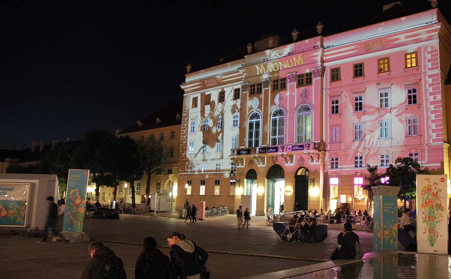 Side courtyard view with pink and black facade projection – MAGNUM PINK BLACK, MuseumsQuartier, Vienna, Austria