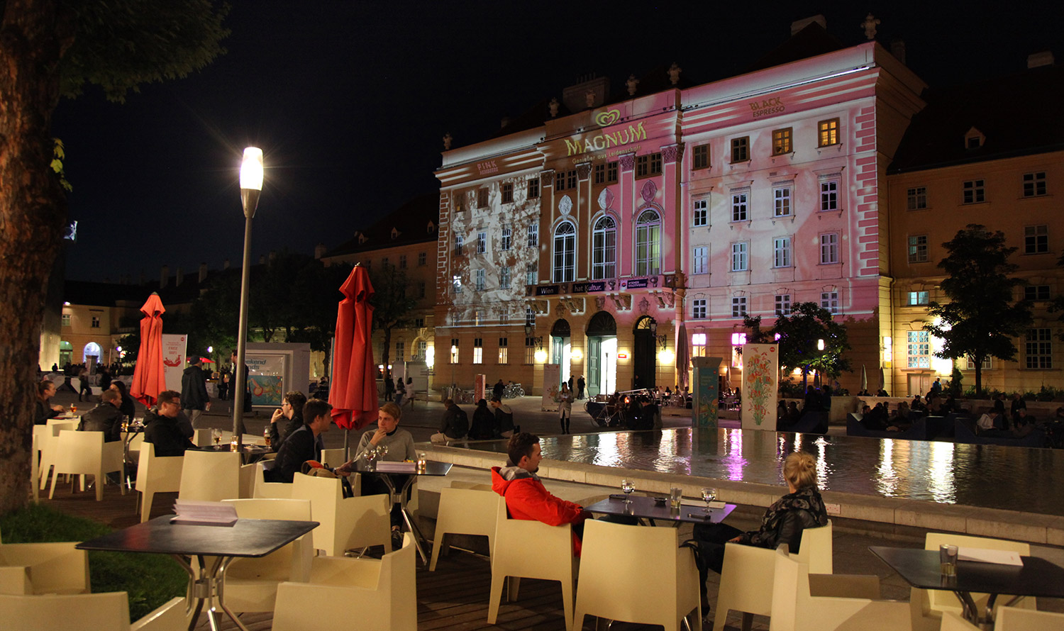 Side courtyard view with pink and black facade projection – MAGNUM PINK BLACK, MuseumsQuartier, Vienna, Austria