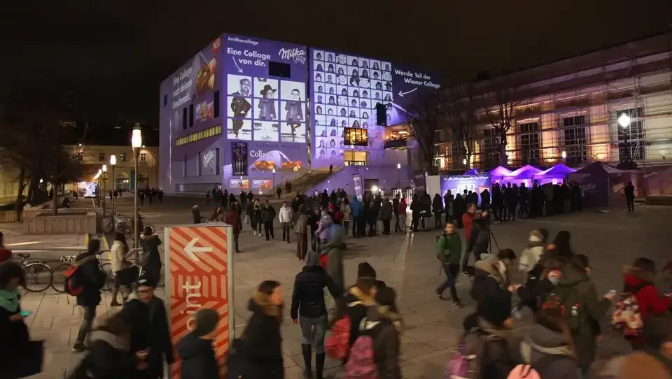 Gäste im Hof vor der projizierten Fotocollage – MILKA, Leopold Museum, Wien, Österreich