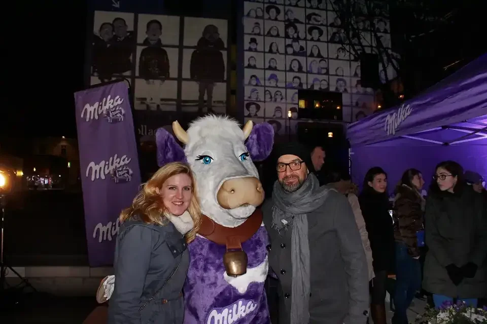 Gäste mit Milka-Kuh-Maskottchen vor der projizierten Fotocollage – MILKA, Leopold Museum, Wien, Österreich