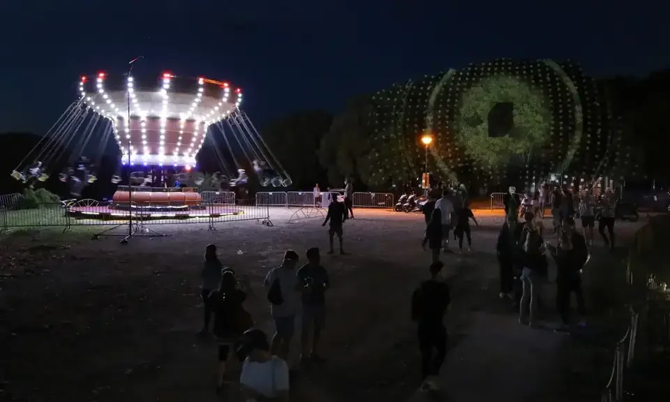 Geometrische Projektionen auf Bäume neben einem Fahrgeschäft – LIGHTHOUSE FESTIVAL 2017, Poreč, Kroatien