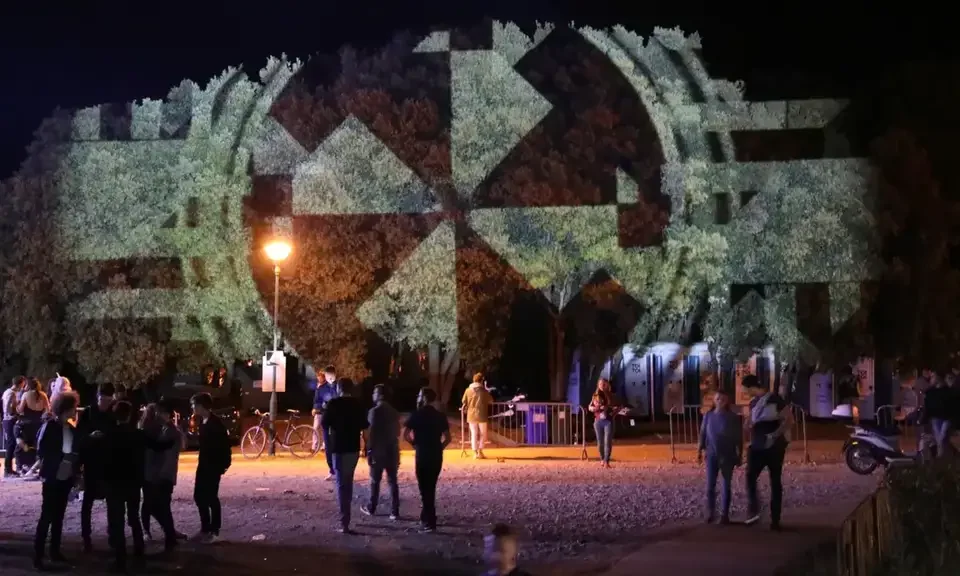 Weiße geometrische Spiralprojektion in Baumkronen über dem Publikum – LIGHTHOUSE FESTIVAL 2017, Poreč, Kroatien