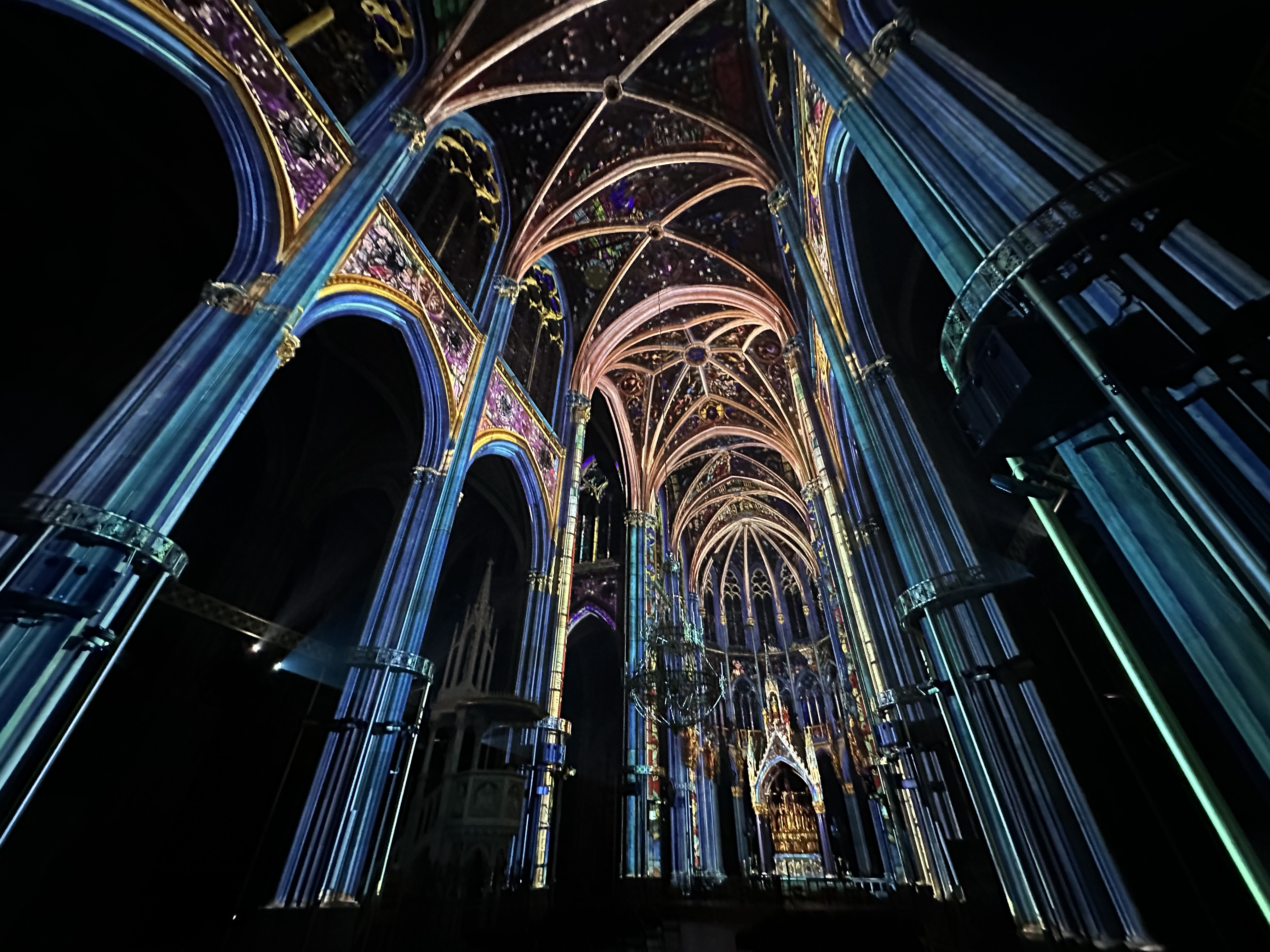 Blaue und goldene Projektionen entlang der Kirchengewölbe – LIGHT OF CREATION, Votivkirche, Wien, Österreich