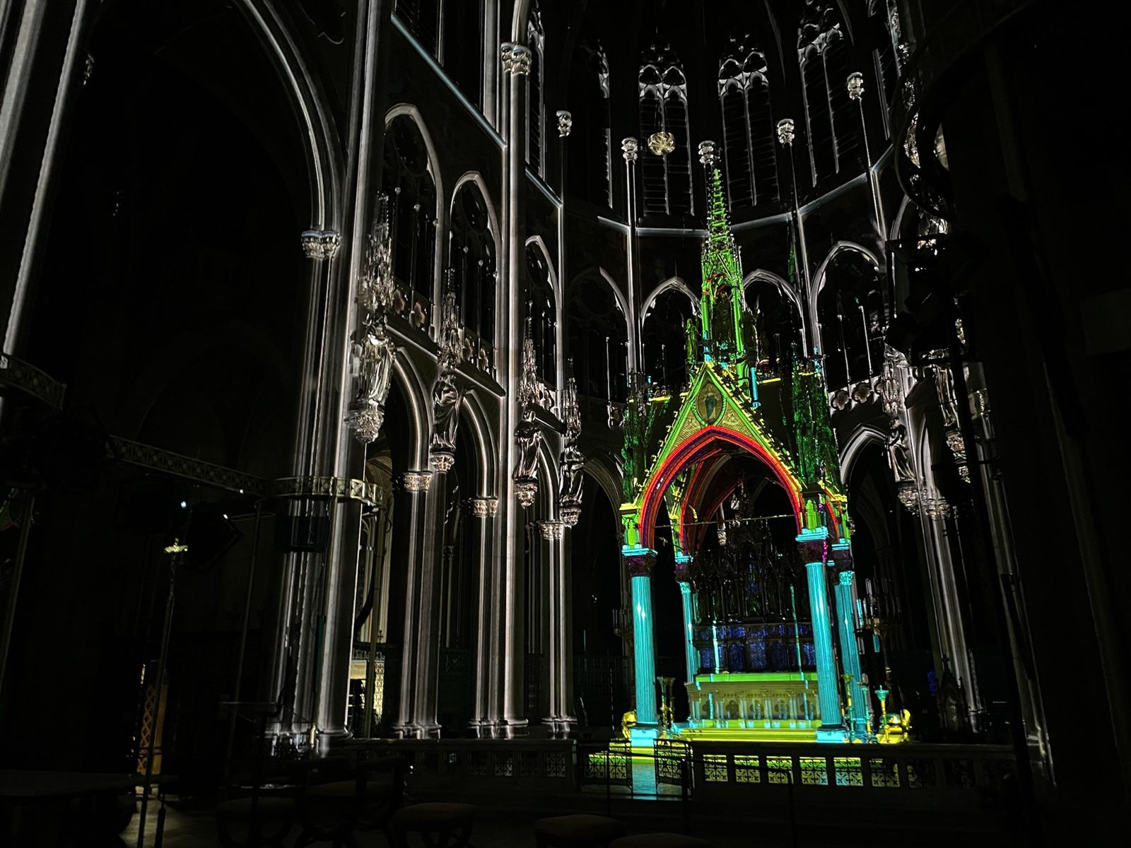 Farbig projizierter Kirchenbogen mit dunkler Umgebung – LIGHT OF CREATION, Votivkirche, Wien, Österreich
