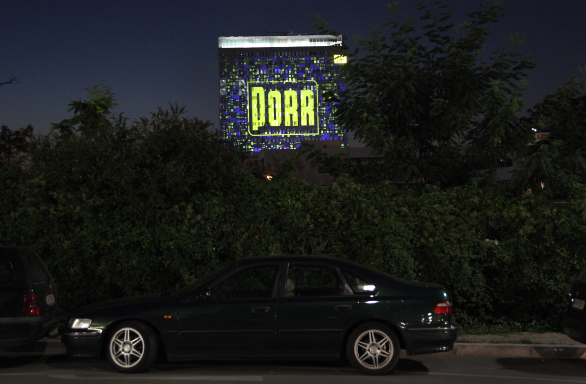 Gelbes PORR-Logo in einer blau-gelben Rasterprojektion auf der Fassade – PORR, Porr Gebäude, Wien, Österreich