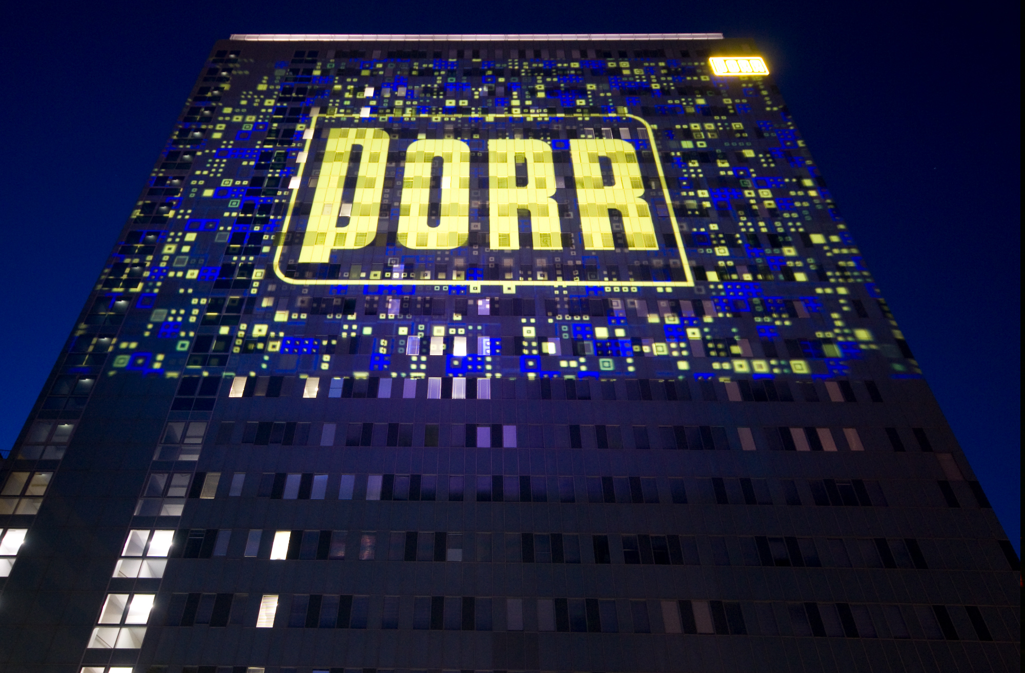 Gelbes PORR-Logo in einer blau-gelben Rasterprojektion auf der Fassade – PORR, Porr Gebäude, Wien, Österreich