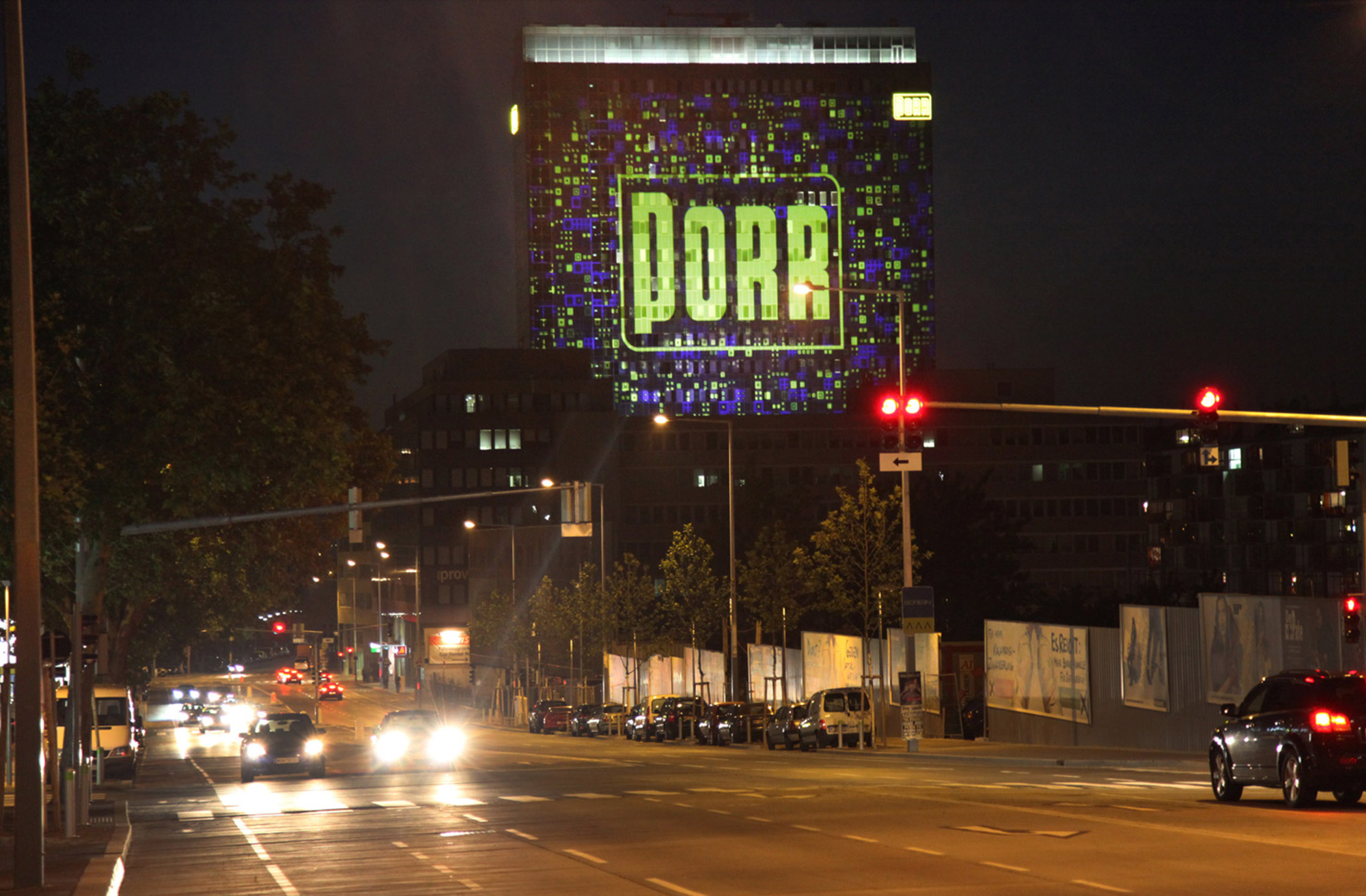 Gelbes PORR-Logo in einer blau-gelben Rasterprojektion auf der Fassade – PORR, Porr Gebäude, Wien, Österreich