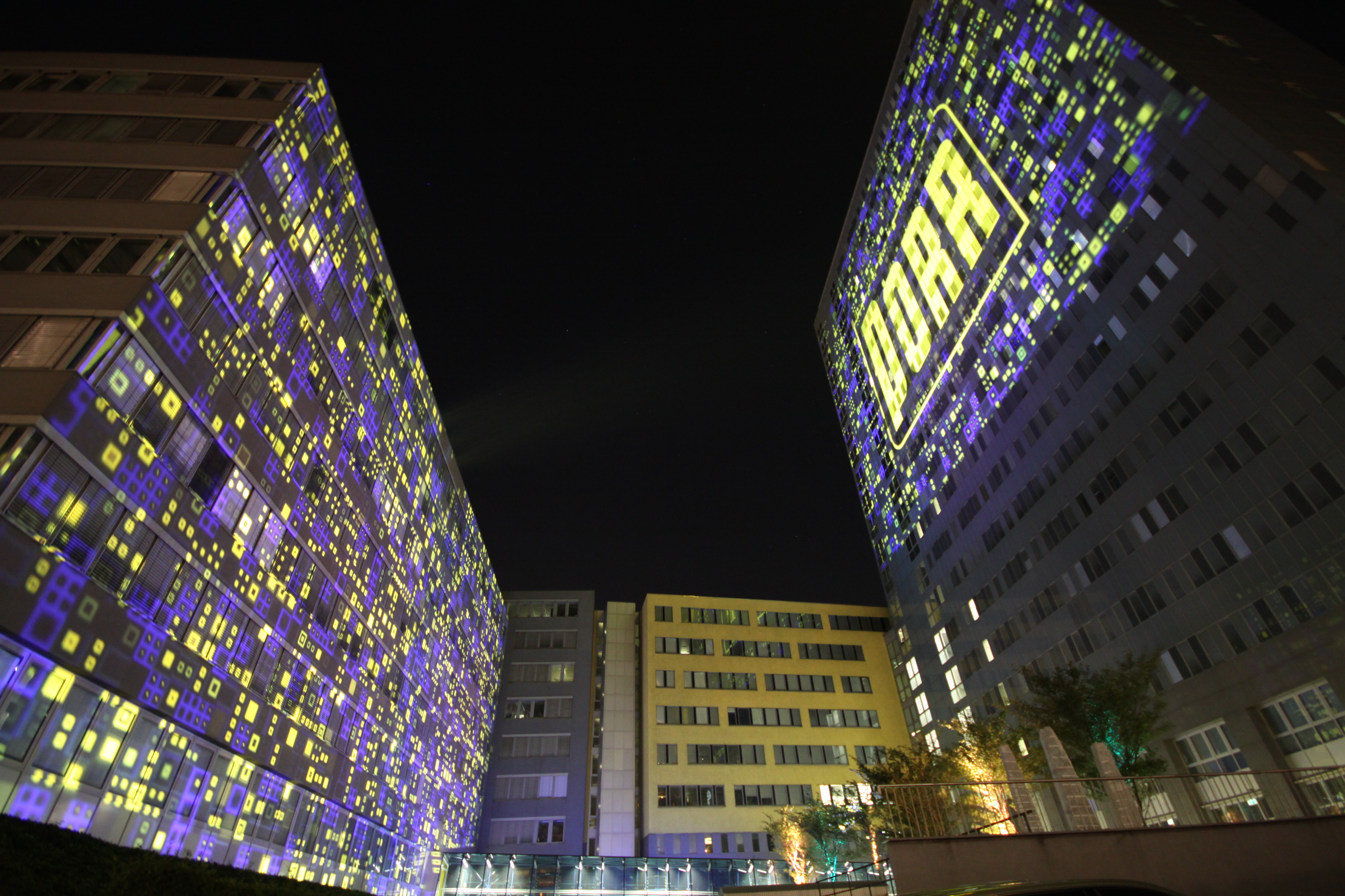 Zwei Gebäudefassaden mit blau-gelben Großbildprojektionen – PORR, Porr Gebäude, Wien, Österreich