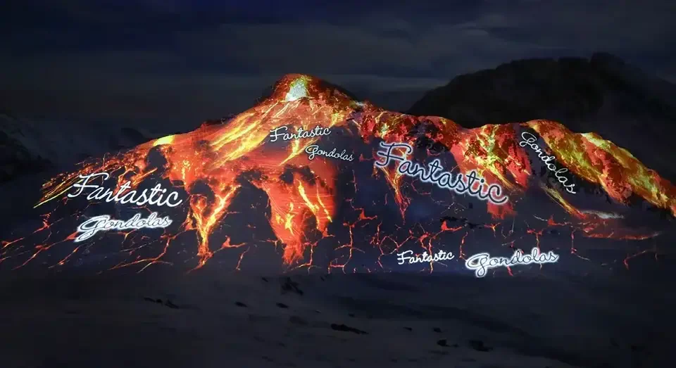 Feuer- und Lavamotive als Großbildprojektion auf einen verschneiten Berg – FANTASTIC GONDOLAS, Lech, Österreich