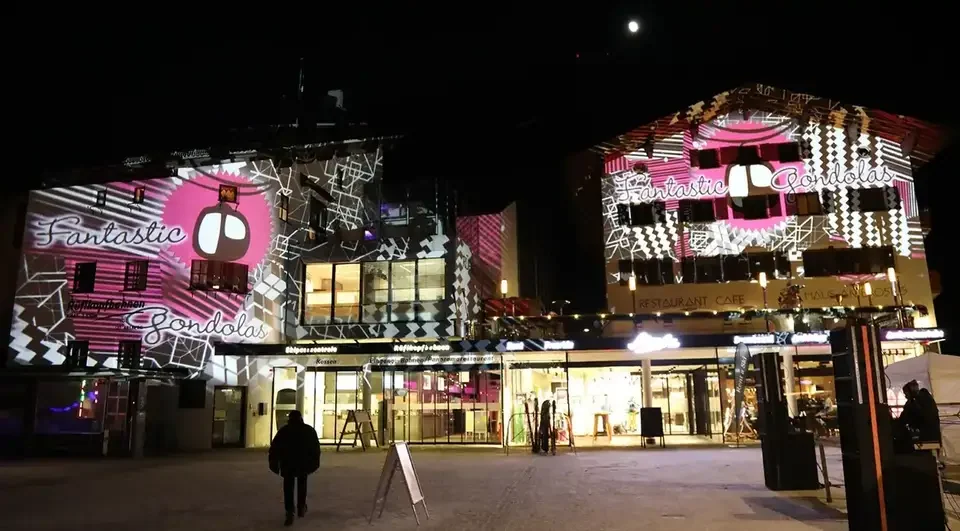 Pinkes Fassadenmapping auf eine Seilbahnstation bei Nacht – FANTASTIC GONDOLAS, Lech, Österreich