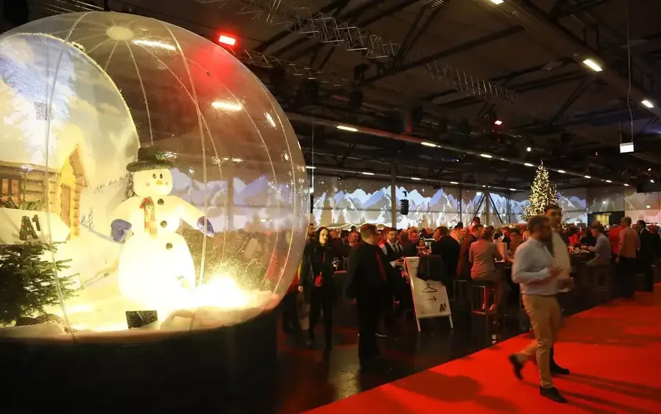Große transparente Schneekugel vor einer winterlichen Raumprojektion – A1 Weihnachtsfeier, Austria Center, Wien, Österreich