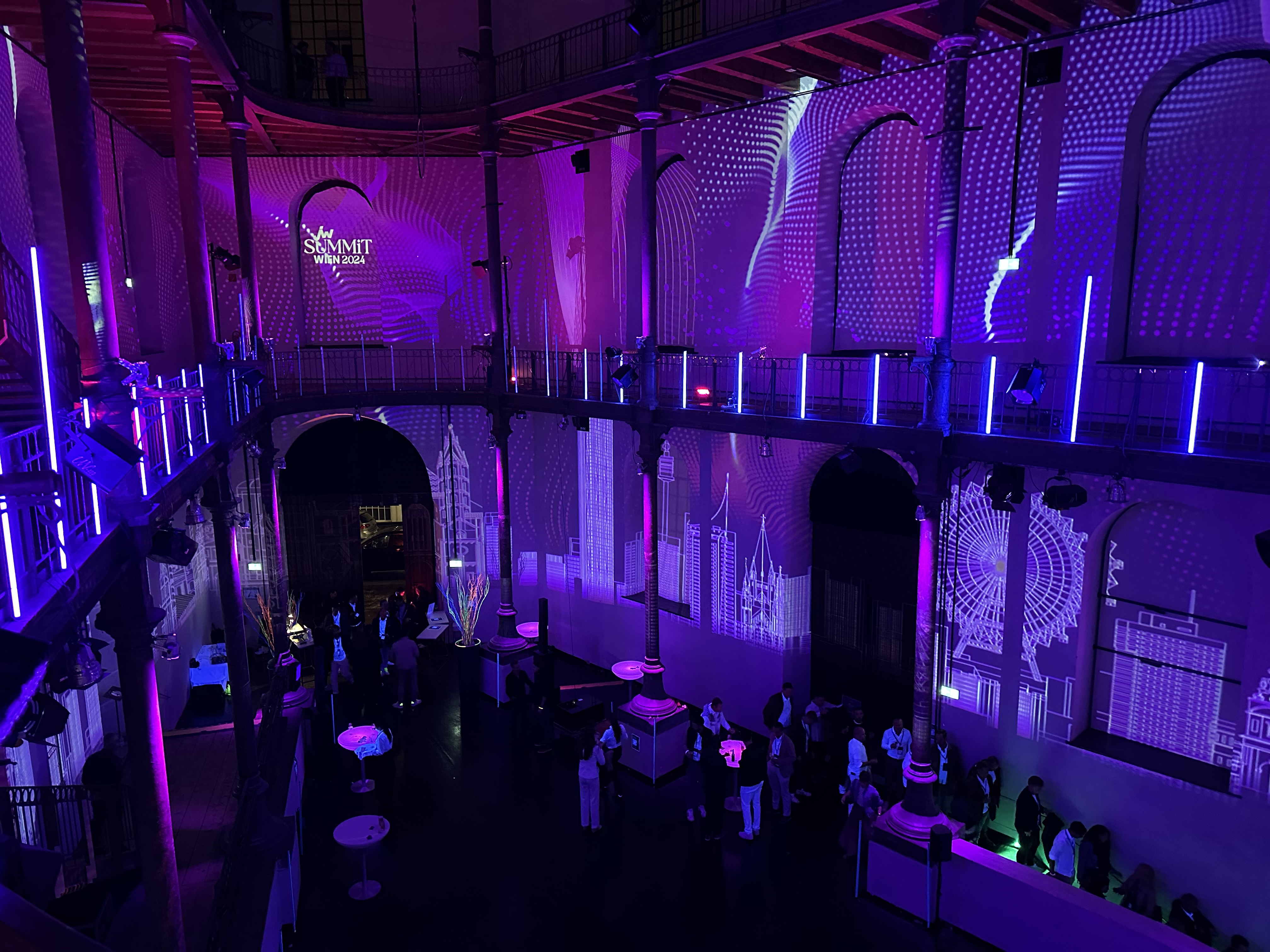 Blick von der Galerie auf violette Raumprojektionen – JW SUMMIT WIEN, Semperdepot, Wien, Österreich