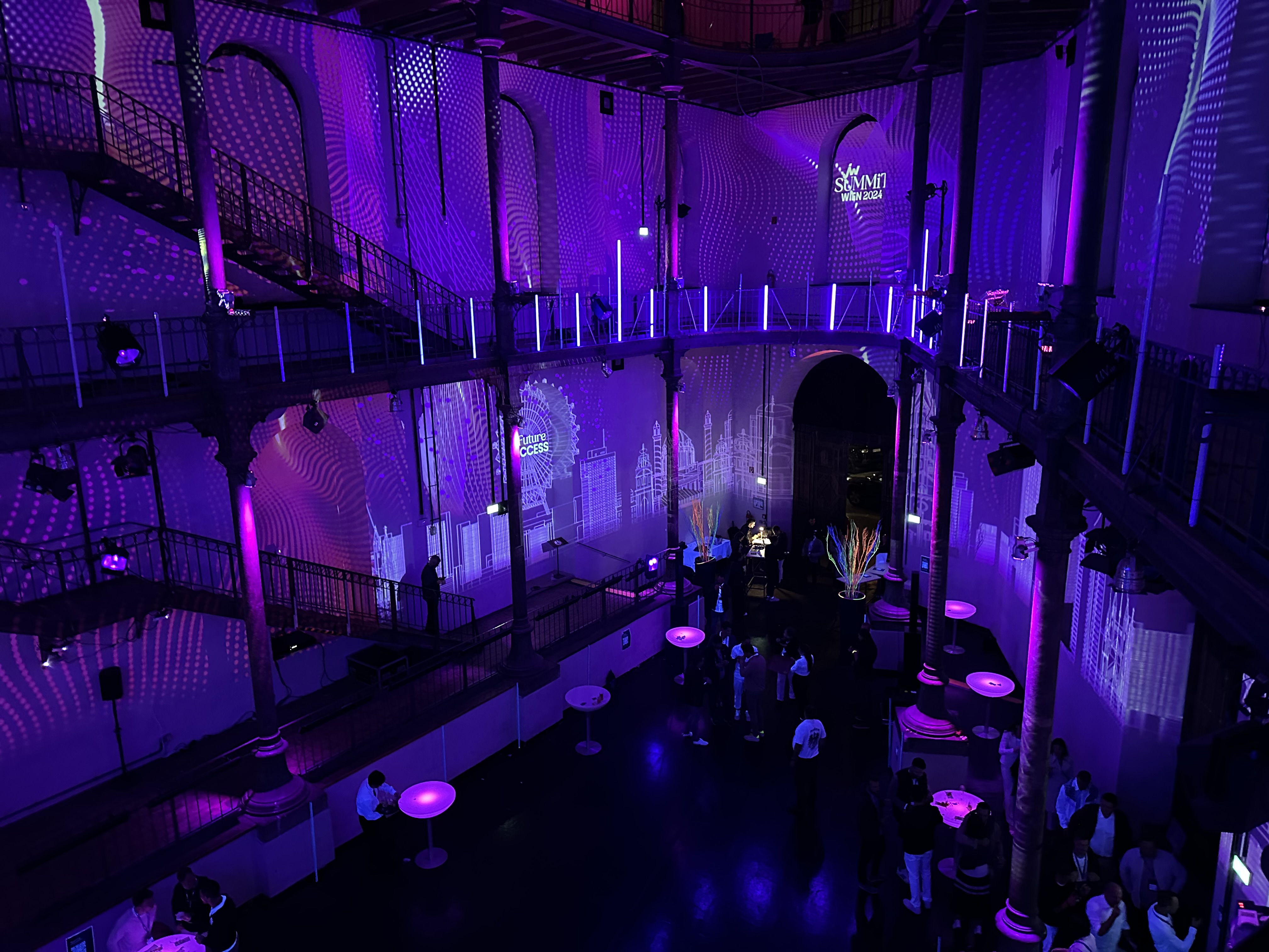 Blick von der Galerie auf violette Raumprojektionen – JW SUMMIT WIEN, Semperdepot, Wien, Österreich