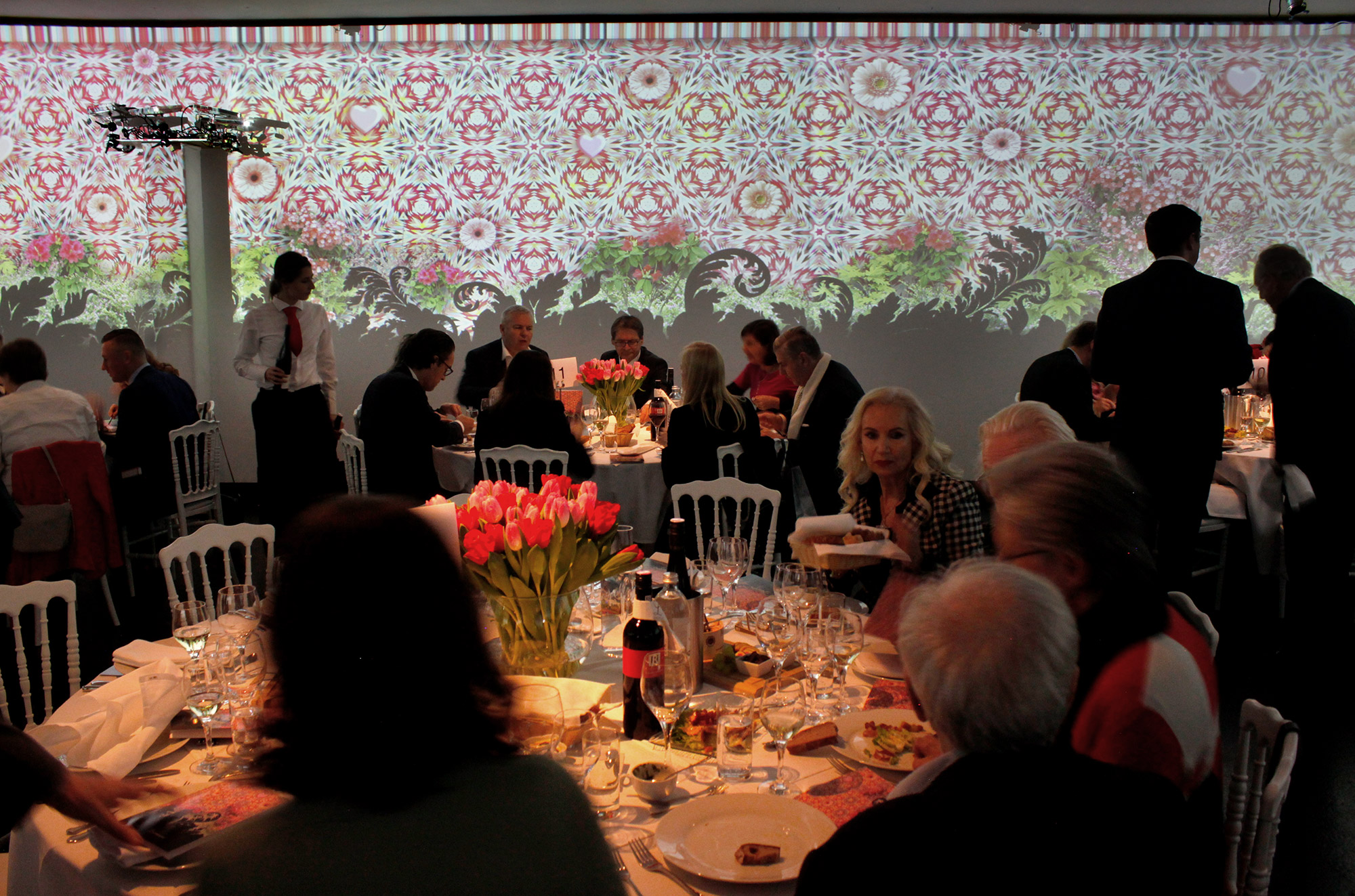 Colourful ornamental and plant imagery projected behind dining tables – Art Brut, Kunstforum, Vienna, Austria