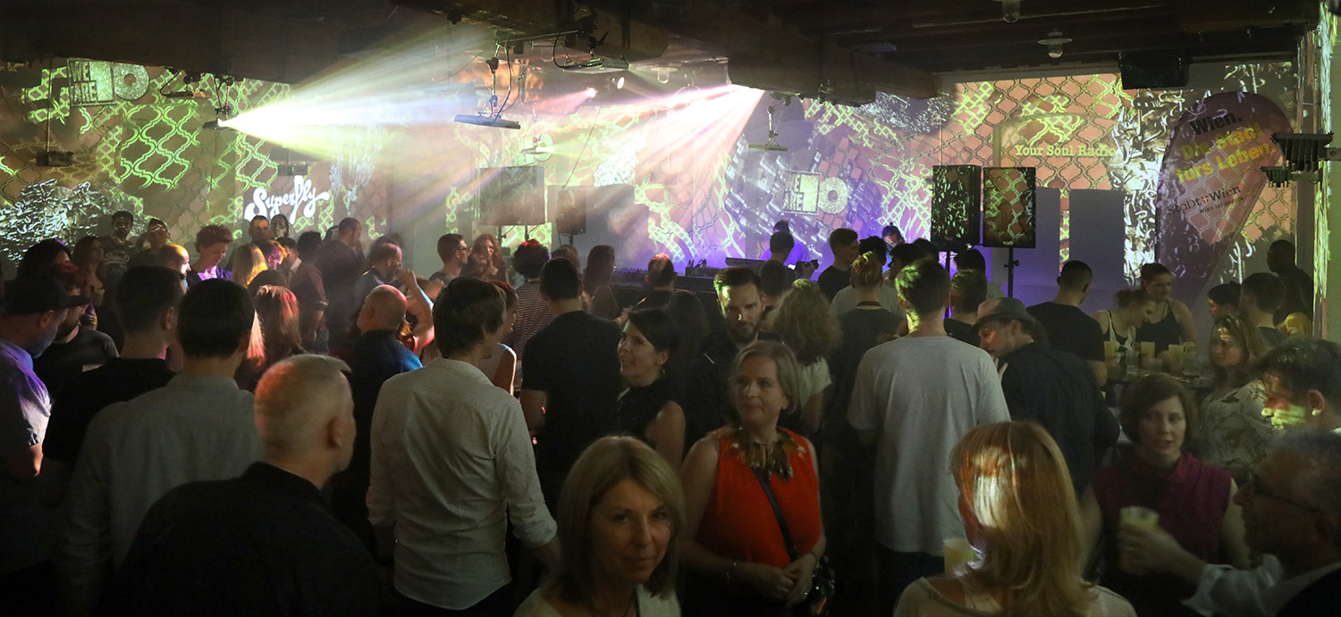 Publikum vor großflächigen Collagen und der Konzertbühne – Superfly, Ottakringer Brauerei, Wien, Österreich