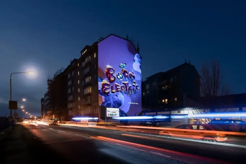 Straßenansicht mit beleuchteter Mural-Projektion und Verkehr – BMW - BORNELECTRIC, Wien, Österreich
