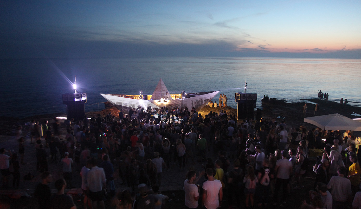 Blick auf das Festivalpublikum am Meer bei Sonnenuntergang – LIGHTHOUSE FESTIVAL, Lanterna, Tar, Kroatien